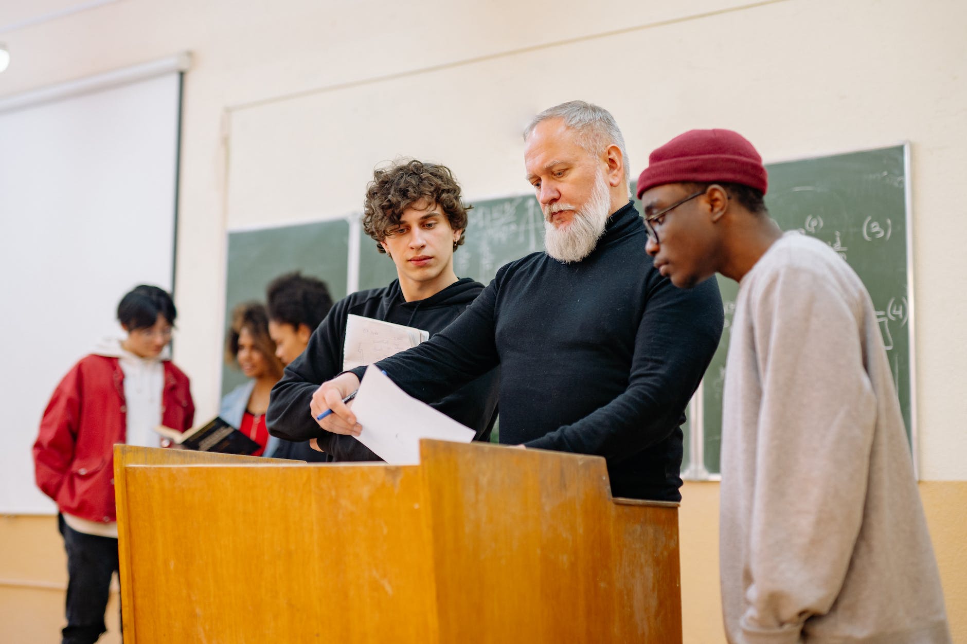 students and teacher in the classroom near brown table