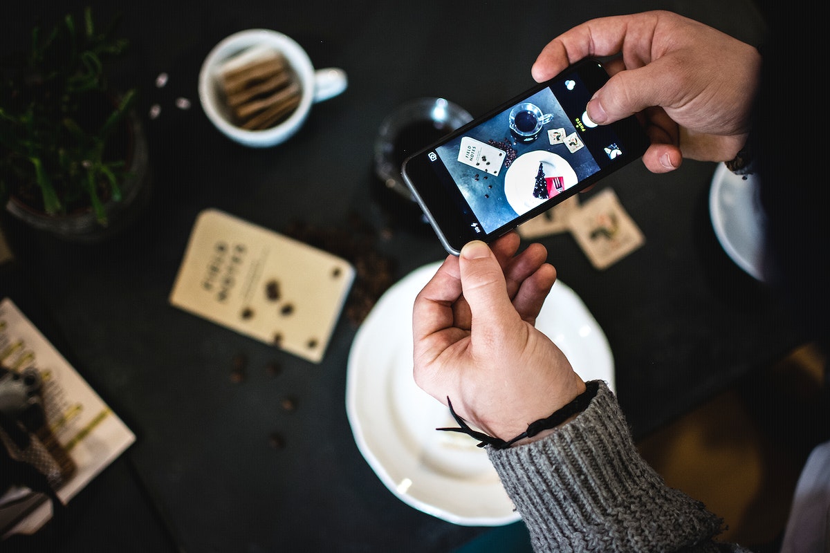 Man taking a photo of a piece of cake with a smartphone